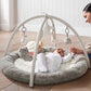 Elephant playmat gym with arch, gray round cushion, and hanging plush toys over baby