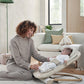 Baby cashmere bouncer seat, beige with infant inside, parent interacting