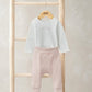 White long-sleeve bodysuit with light pink ribbed leggings, cuffed ankle hems