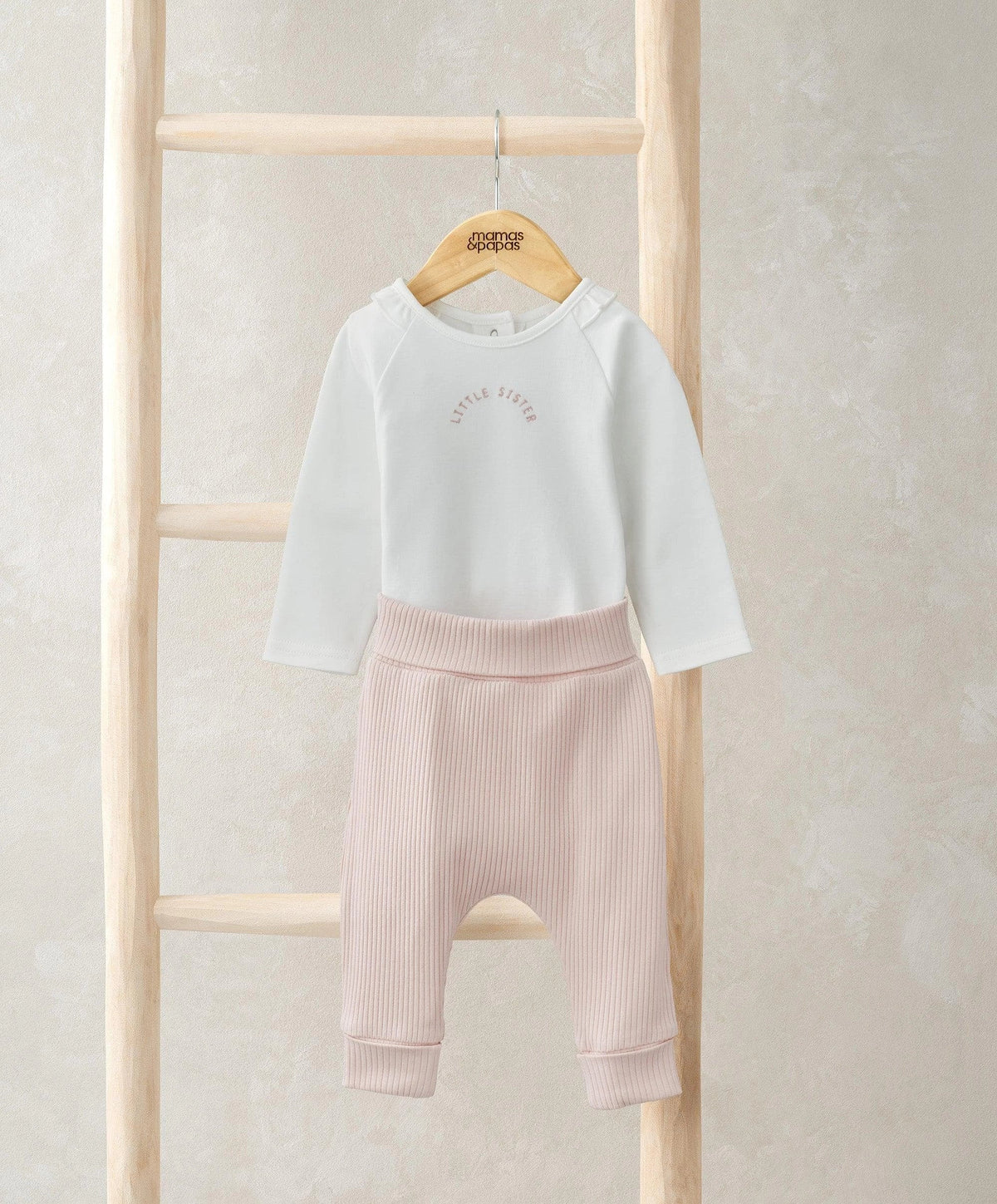 White long-sleeve bodysuit with light pink ribbed leggings, cuffed ankle hems