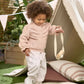 Light pink knitted cardigan with embroidered front and long sleeves worn with pants
