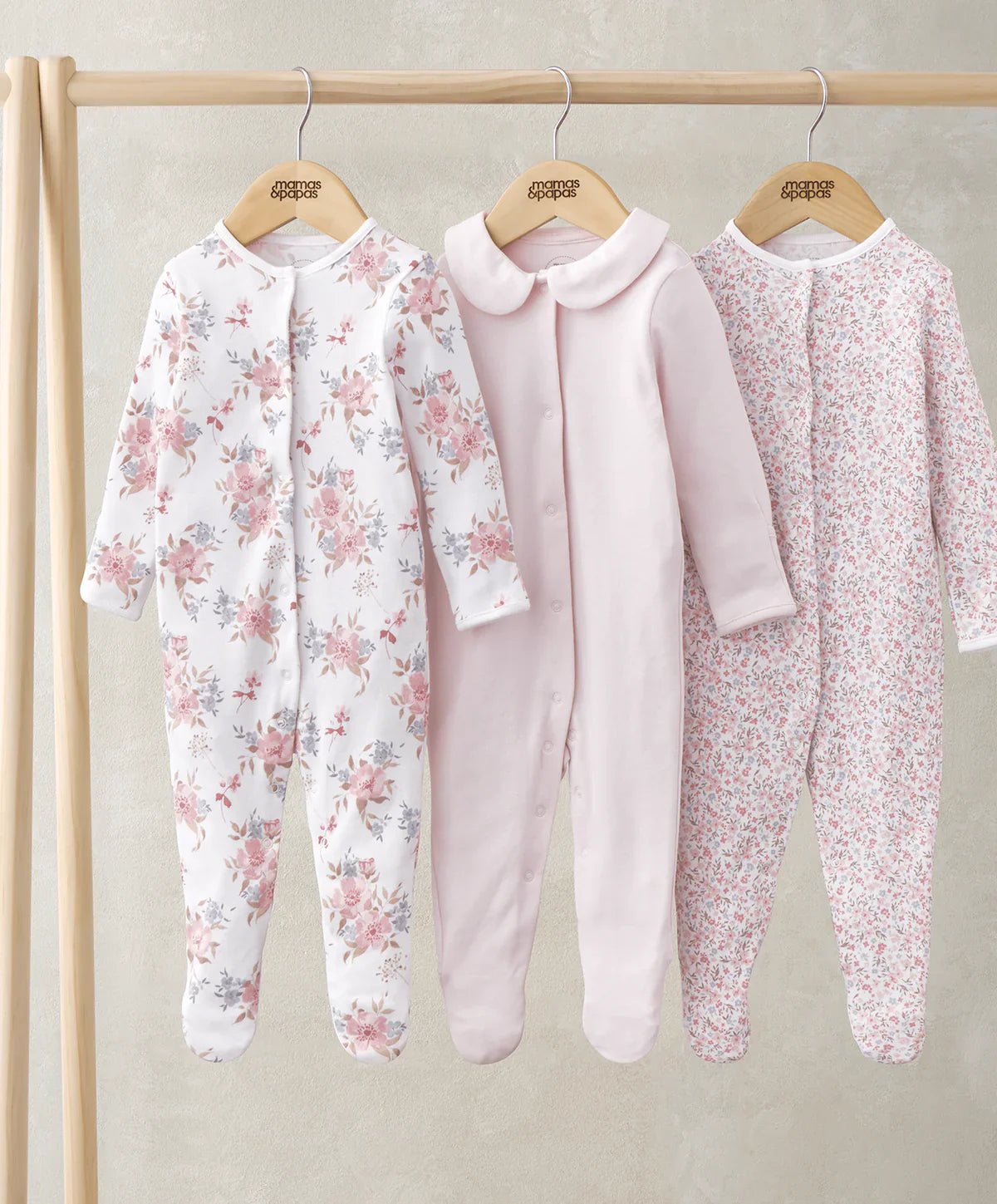 Three long-sleeve sleepsuits: floral white, pale pink, and pink ditsy print