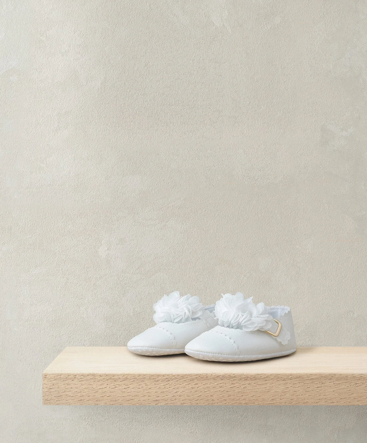 White scalloped-edge ballet shoes with white flower appliques on the toes
