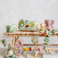 Lion mini rattle plush on wooden shelf among colorful baby toys