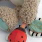 Plush hippo activity toy close-up with ladybug plush and teal fabric paw pads