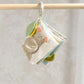 Cloth baby activity book with animal faces and fabric pages, hanging from a clip