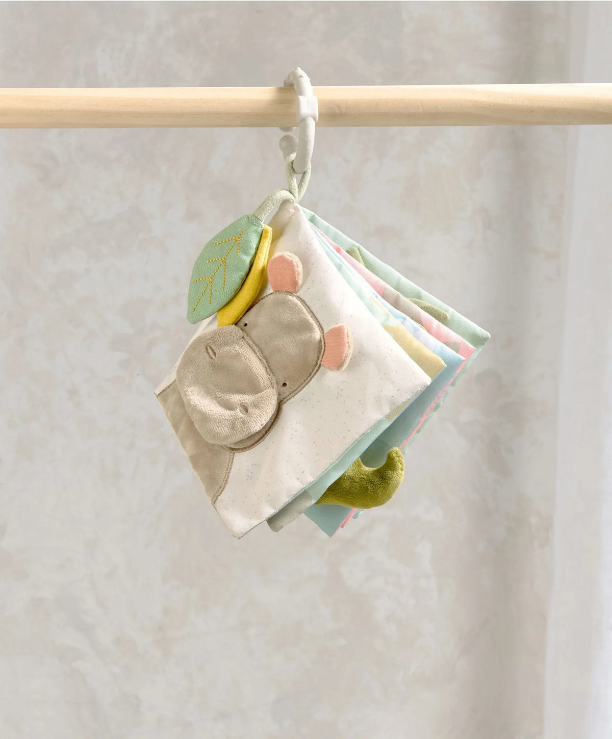 Cloth baby activity book with animal faces and fabric pages, hanging from a clip