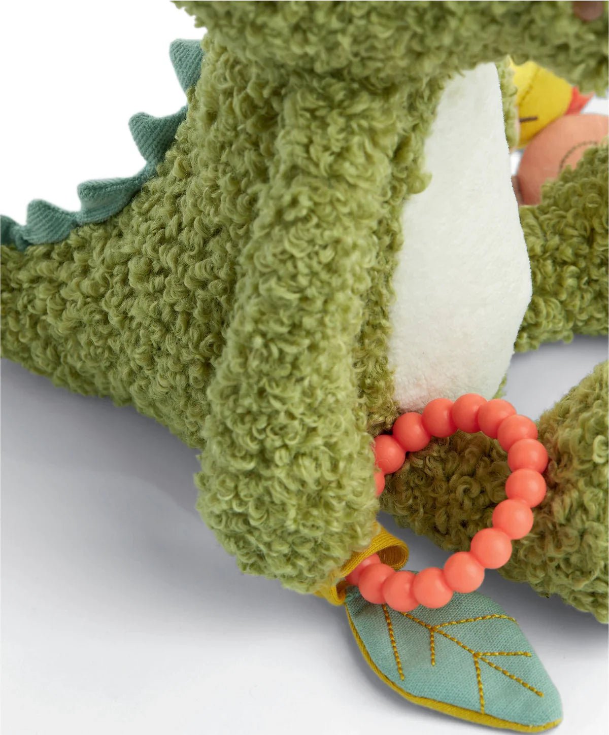 Green plush crocodile toy leg with orange bead ring and blue stitched fabric fin