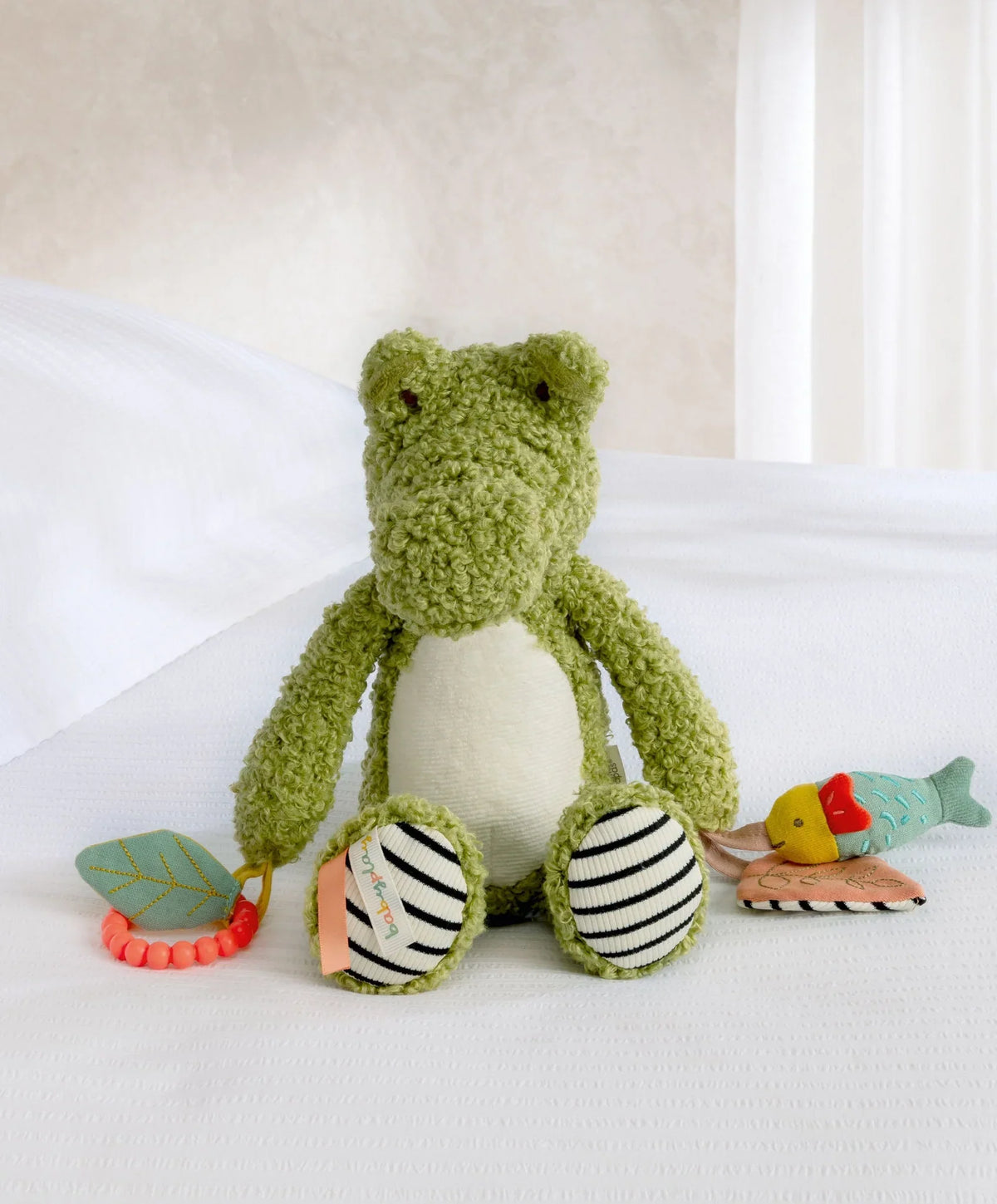 Plush green crocodile activity toy with striped feet, textured teether and hanging parts