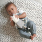 Plush zebra activity toy with striped legs and fabric ring teether, held by baby