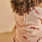 Close-up of blush floral knit top with button placket and ribbed collar