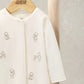 Cream romper with embroidered bear characters on chest and full-length legs