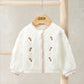 White embroidered cable knit cardigan with button front and small floral motifs