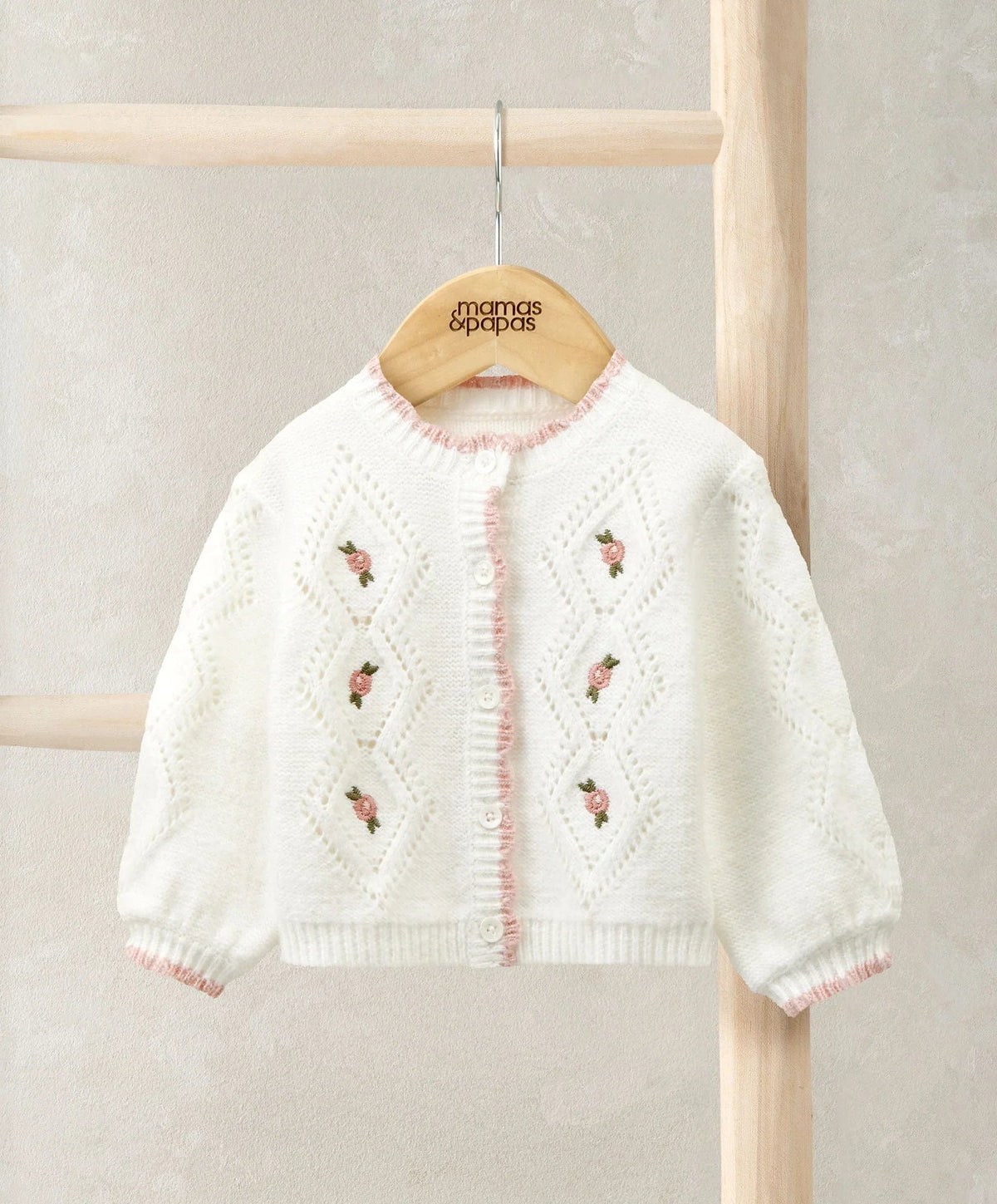 White embroidered cable knit cardigan with button front and small floral motifs
