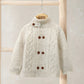 Cream cable knit cardigan with funnel neck, button placket, and brown buttons