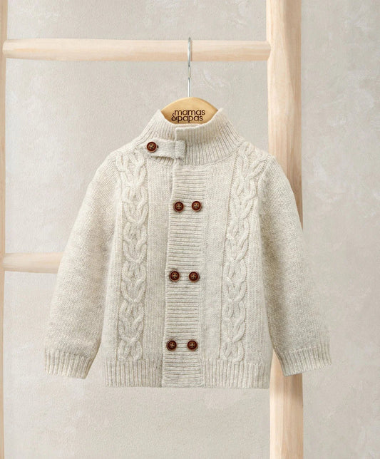 Cream cable knit cardigan with funnel neck, button placket, and brown buttons