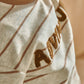 Cream striped t-shirt close-up with textured brown Adventure lettering