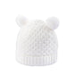 White rib knit beanie with fuzzy pom poms, textured knit, and ribbed cuff