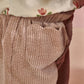 Pink cord trousers close-up of elastic waistband and side seam pocket