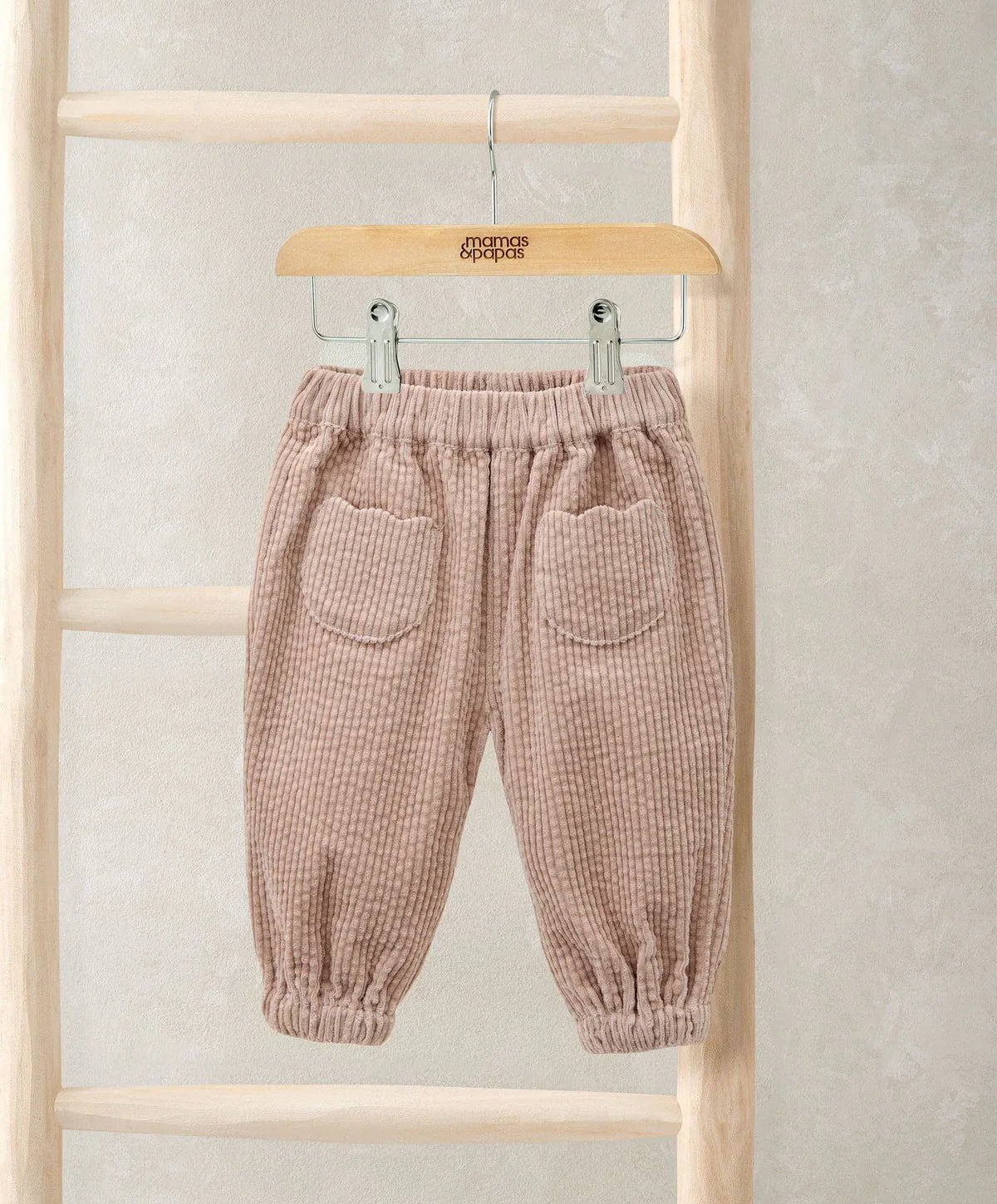 Pink cord trousers with elastic waistband and two front patch pockets