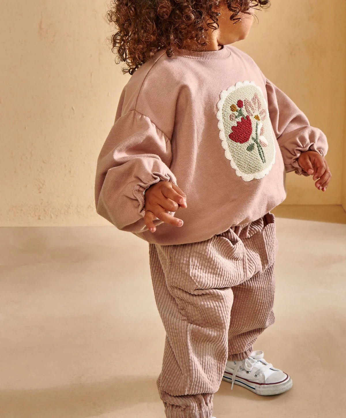Pink sweatshirt with floral appliqué on back panel, ribbed neckline, balloon sleeves