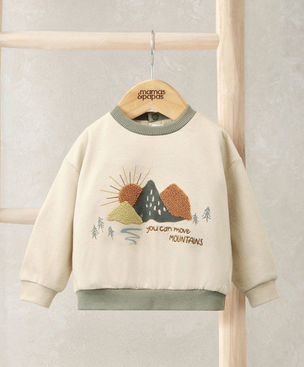 Cream crewneck sweatshirt with embroidered mountains and sunburst graphic, ribbed cuffs