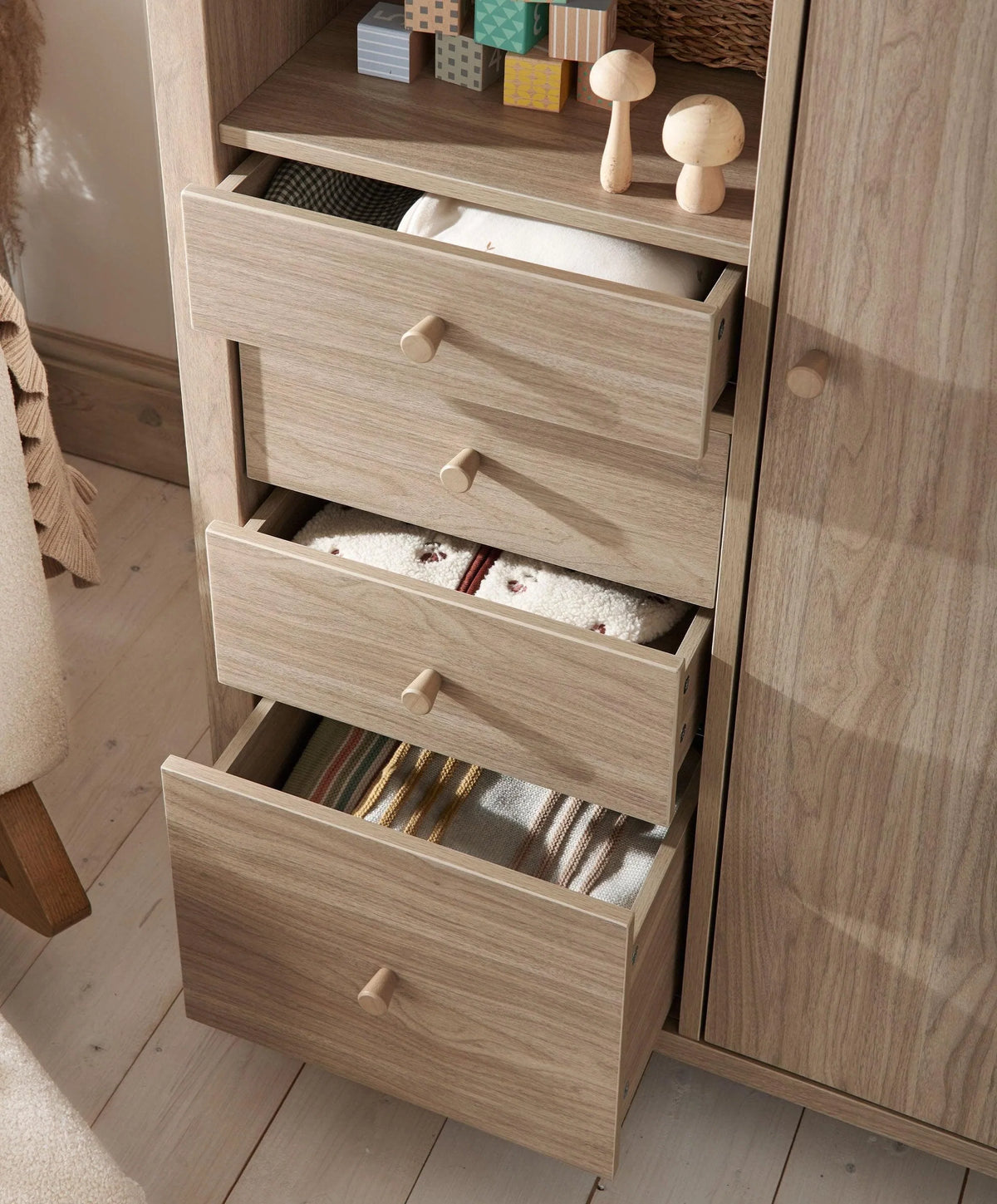 Oak-finish wardrobe with three pull-out drawers and round wooden knobs
