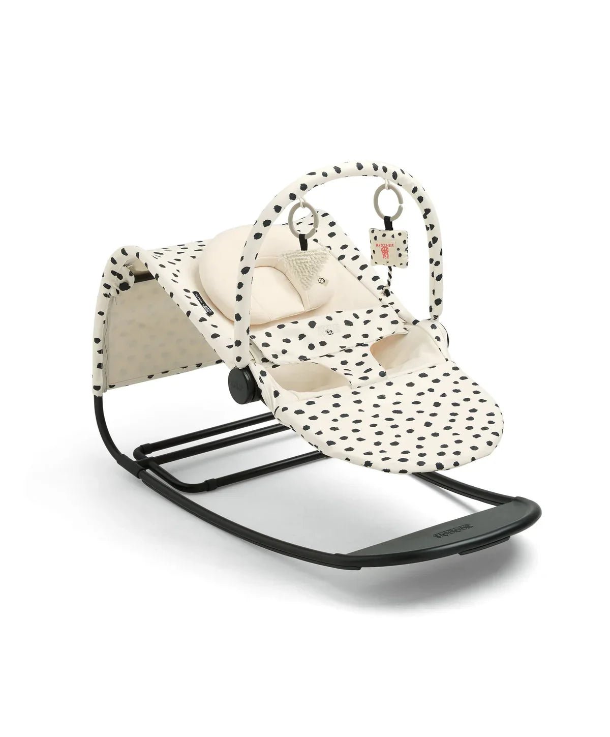 Cream and black spot baby bouncer seat with hanging toy straps