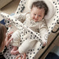 Cheetah spot baby bouncer with smiling infant seated in padded harness