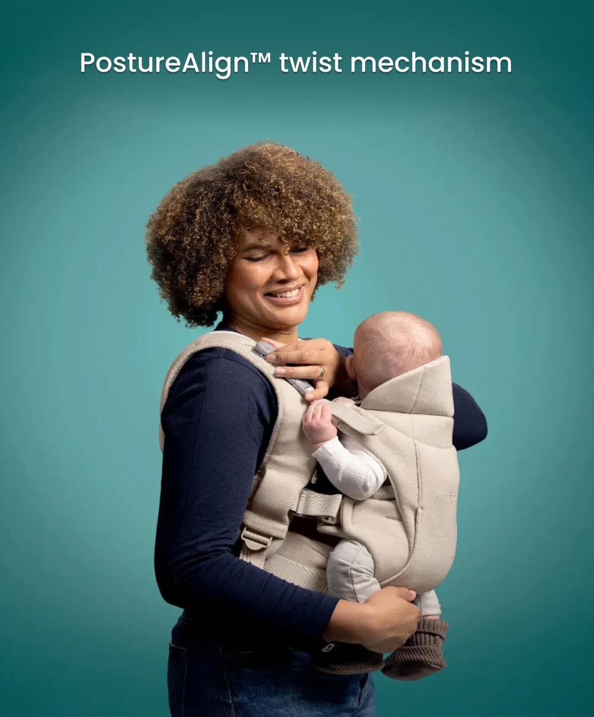 Black baby carrier with seated infant facing inward, parent wearing it