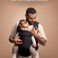 Black baby carrier with magnetic-style buckles, padded seat, and adjustable shoulder straps