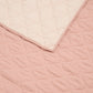 Baby quilt close-up of pink and cream stitched edges with quilted texture