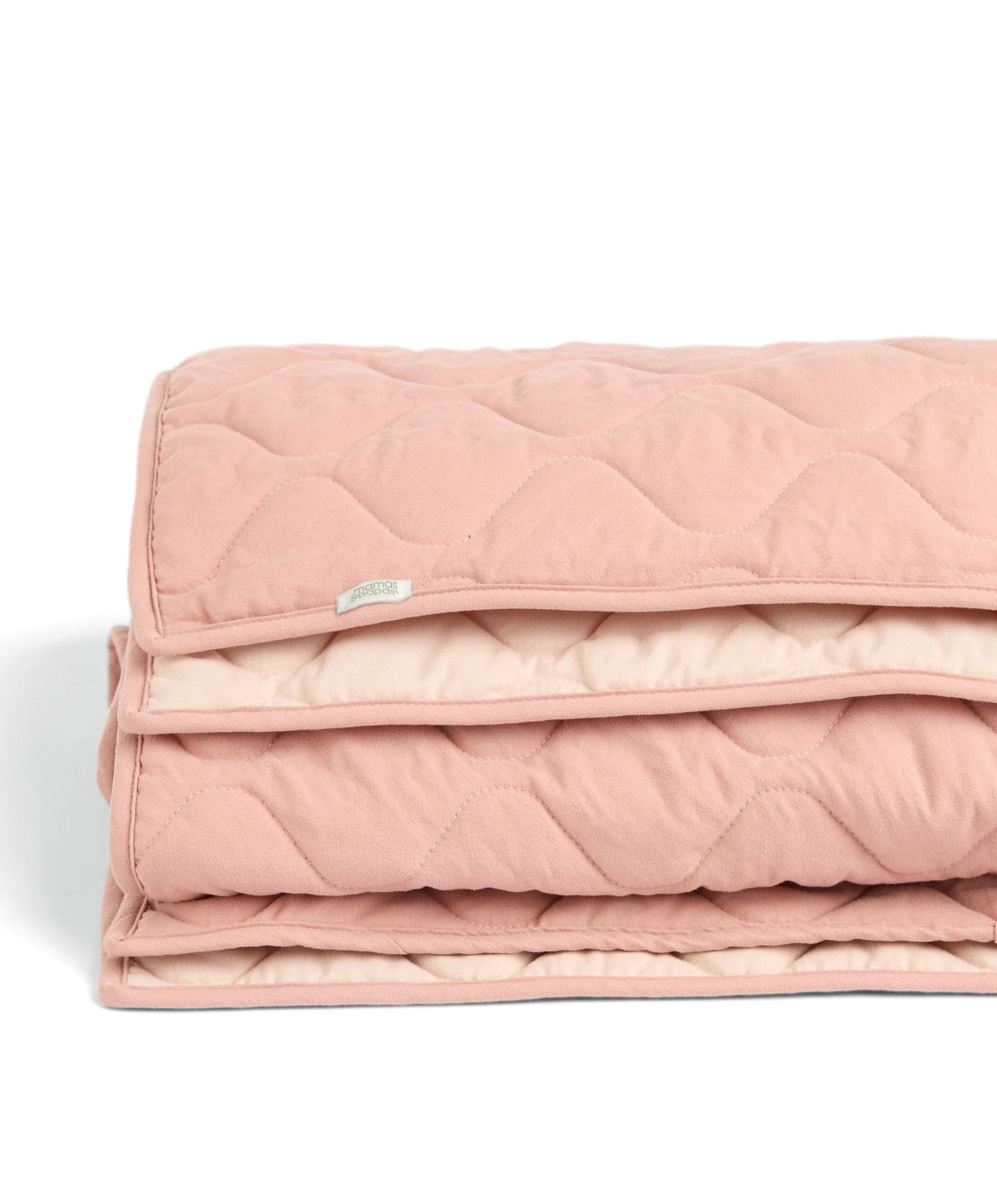 Folded baby quilt in light pink, showing layered quilted padding and stitched edge
