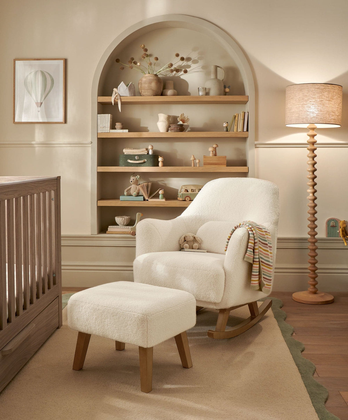 Off-white bouclé nursing chair with padded stool, curved wooden rocker base