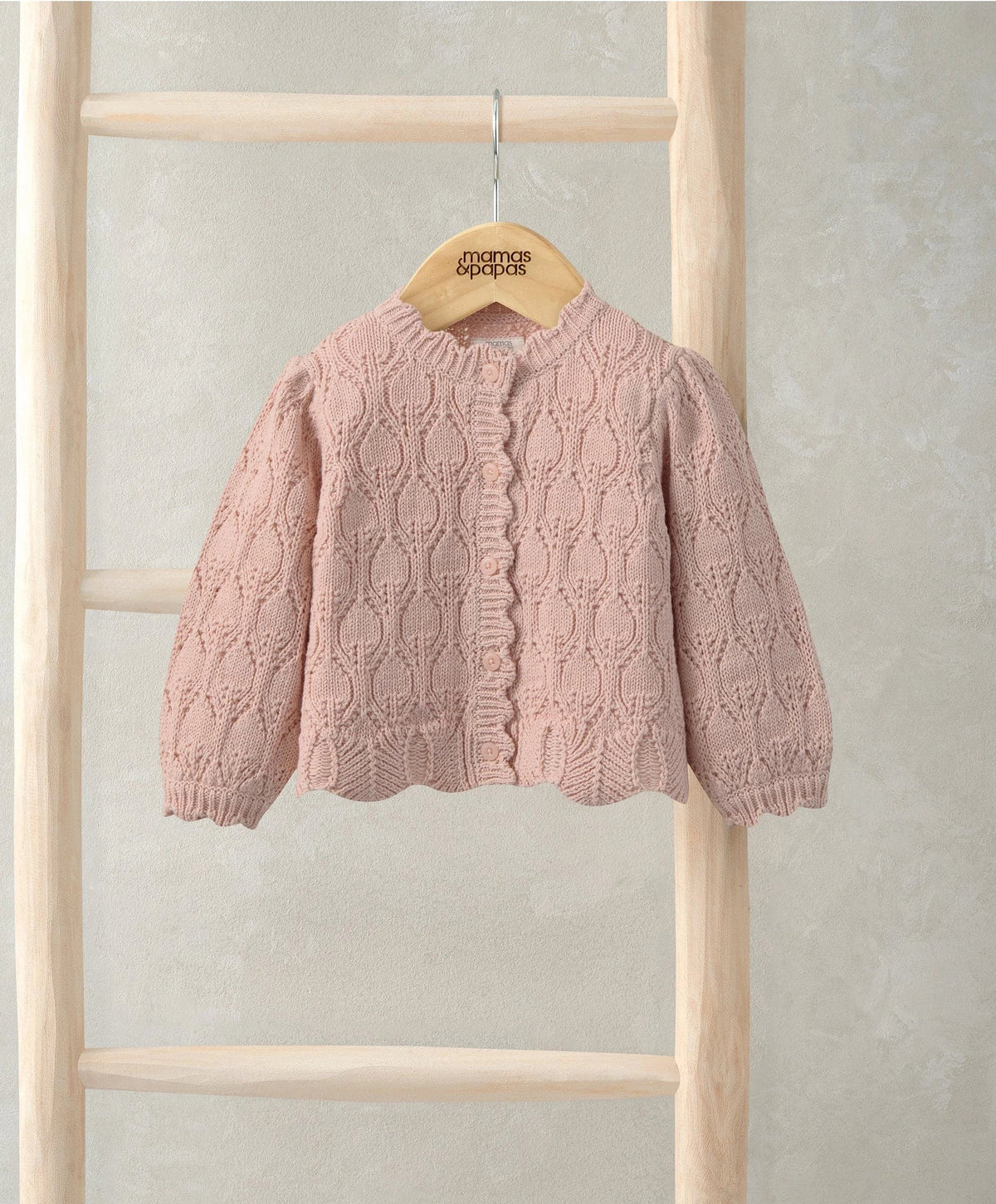 Pink knit cardigan with button front, textured cable pattern, ribbed cuffs and collar