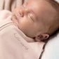 Pink zip-front swaddle sleeping bag close-up, newborn asleep