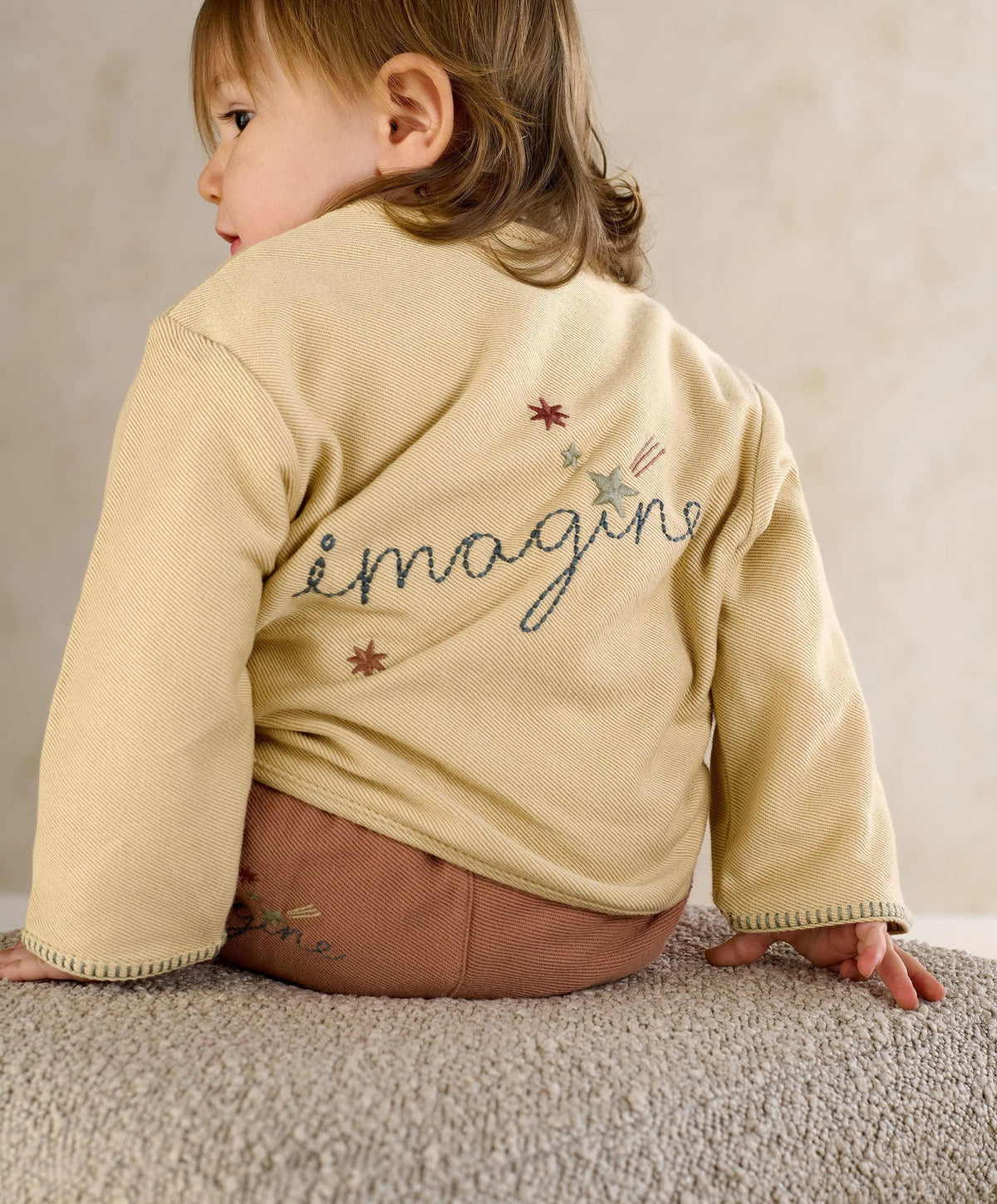 Cream kids jacket back view with embroidered imagine logo and star details