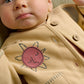 Cream kids jacket with embroidered smiling sun patch and buttoned front