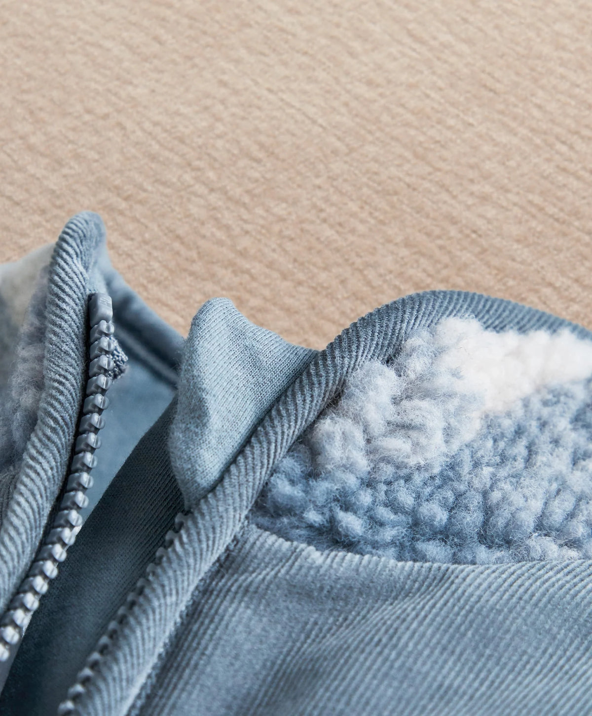 Fleece-lined pramsuit cuff with blue fabric trim and stitched seam detail