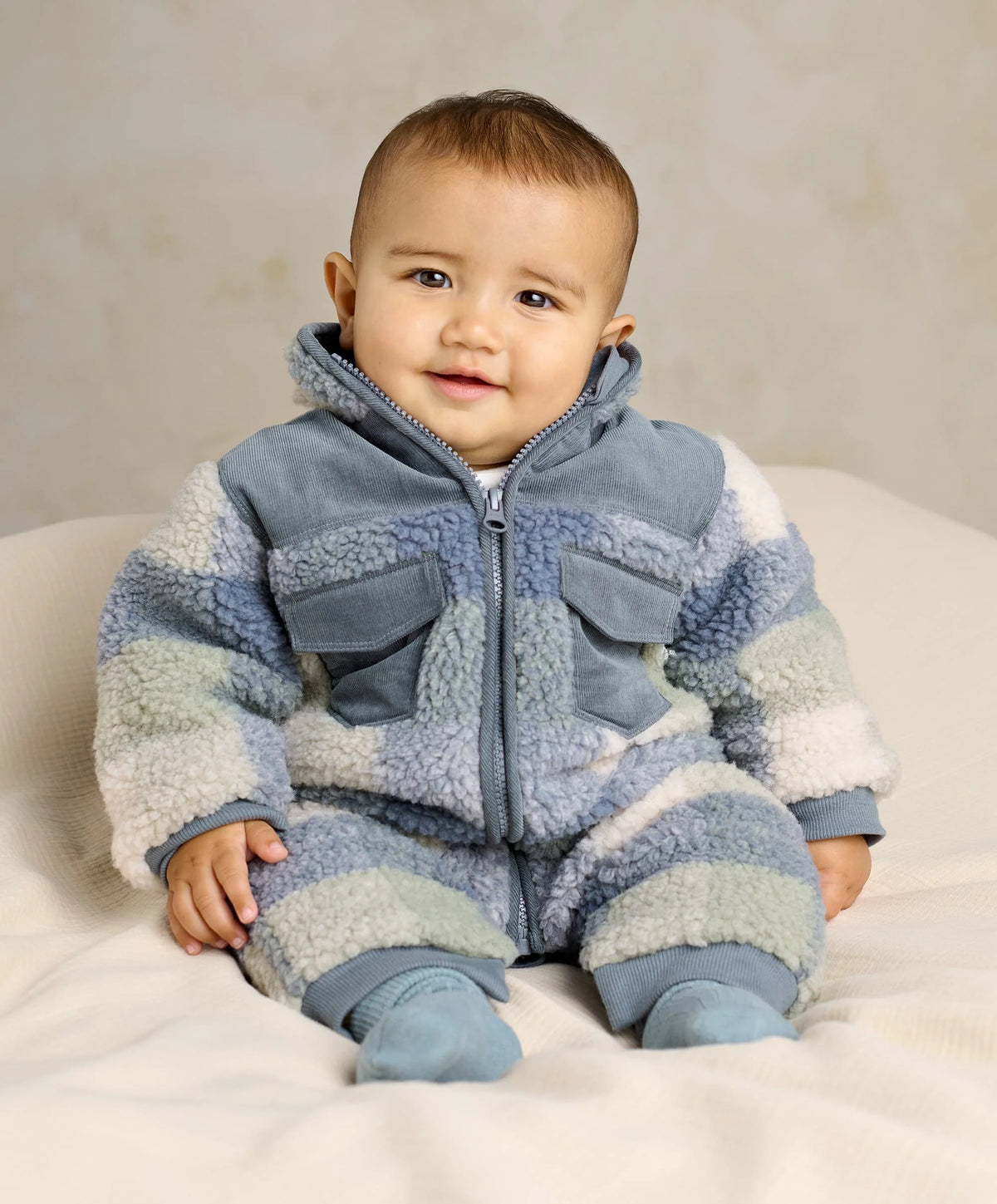 Blue and white fleece pramsuit with zip front, hood, and patch pockets