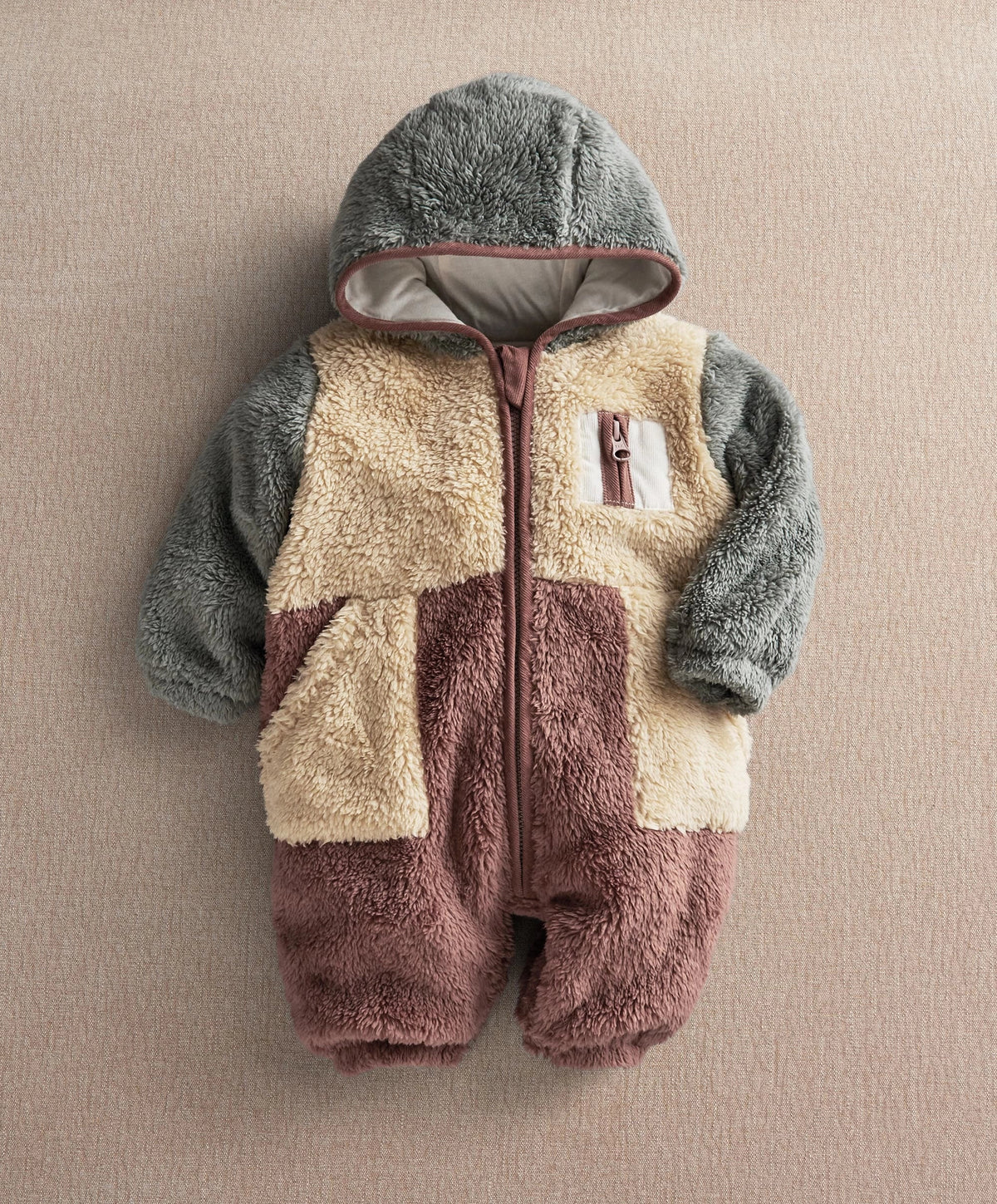 Color-block pramsuit with hooded front and buttoned zipper, gray sleeves, beige and plum panels