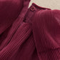 Burgundy button-up neckline with pleated cape detail