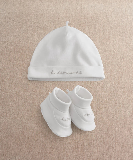 White baby beanie hat and booties set with cursive text accents