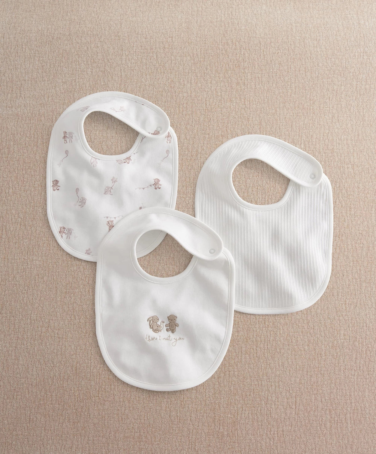 Three white baby bibs with brown animal prints, ribbed bib opening and snap fasteners