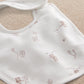 White baby bib with brown and pink animal print, rounded neckline and stitched trim