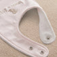 Pink baby bib with snap buttons at bottom and embroidered 'born in 2027'