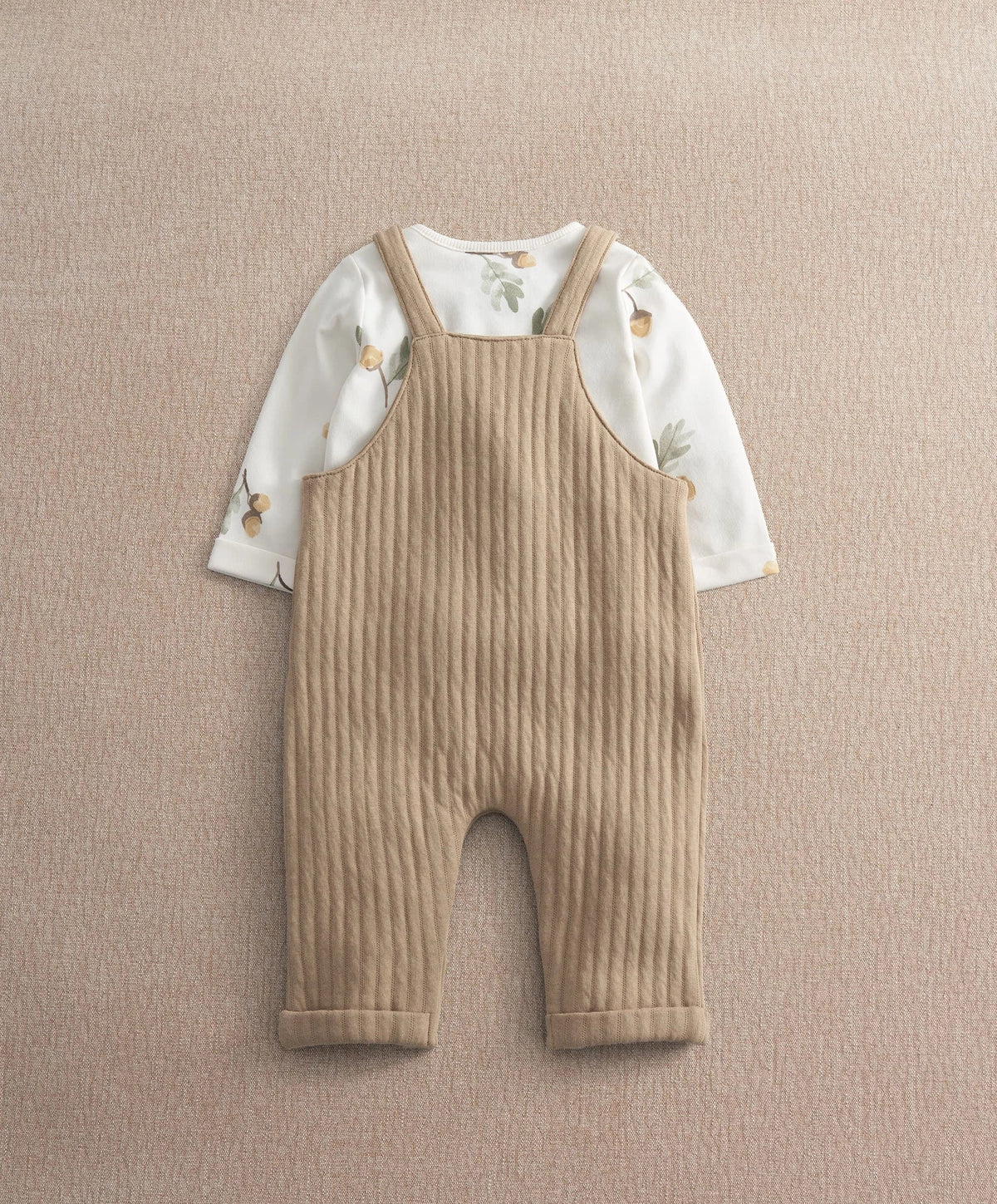 Baby dungaree and bodysuit set: tan ribbed overalls over white acorn-print sleeves