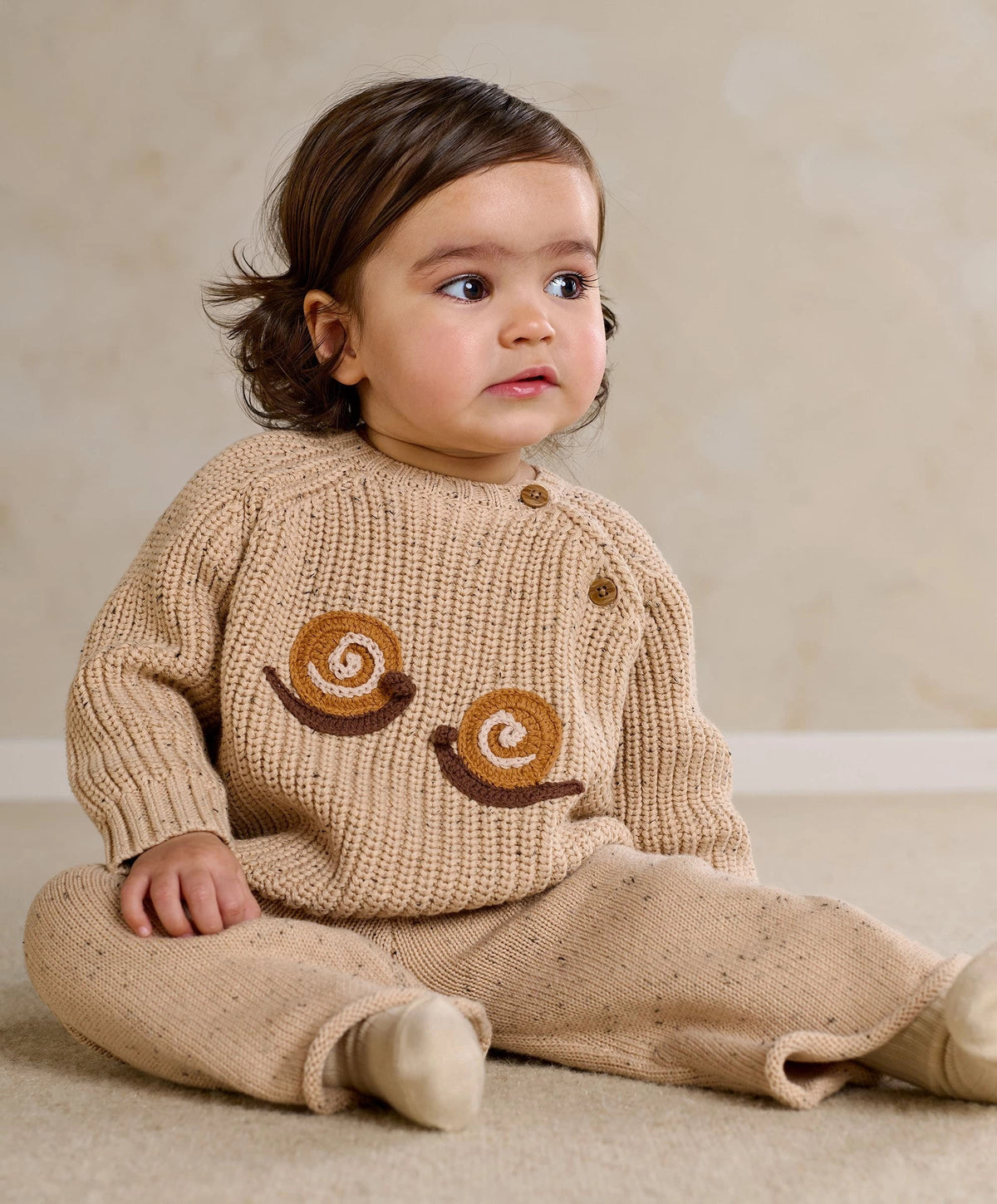 Beige knitted baby set with snail applique sweater and matching pants