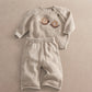Cream knit sweater with brown snail appliques and matching speckled pants