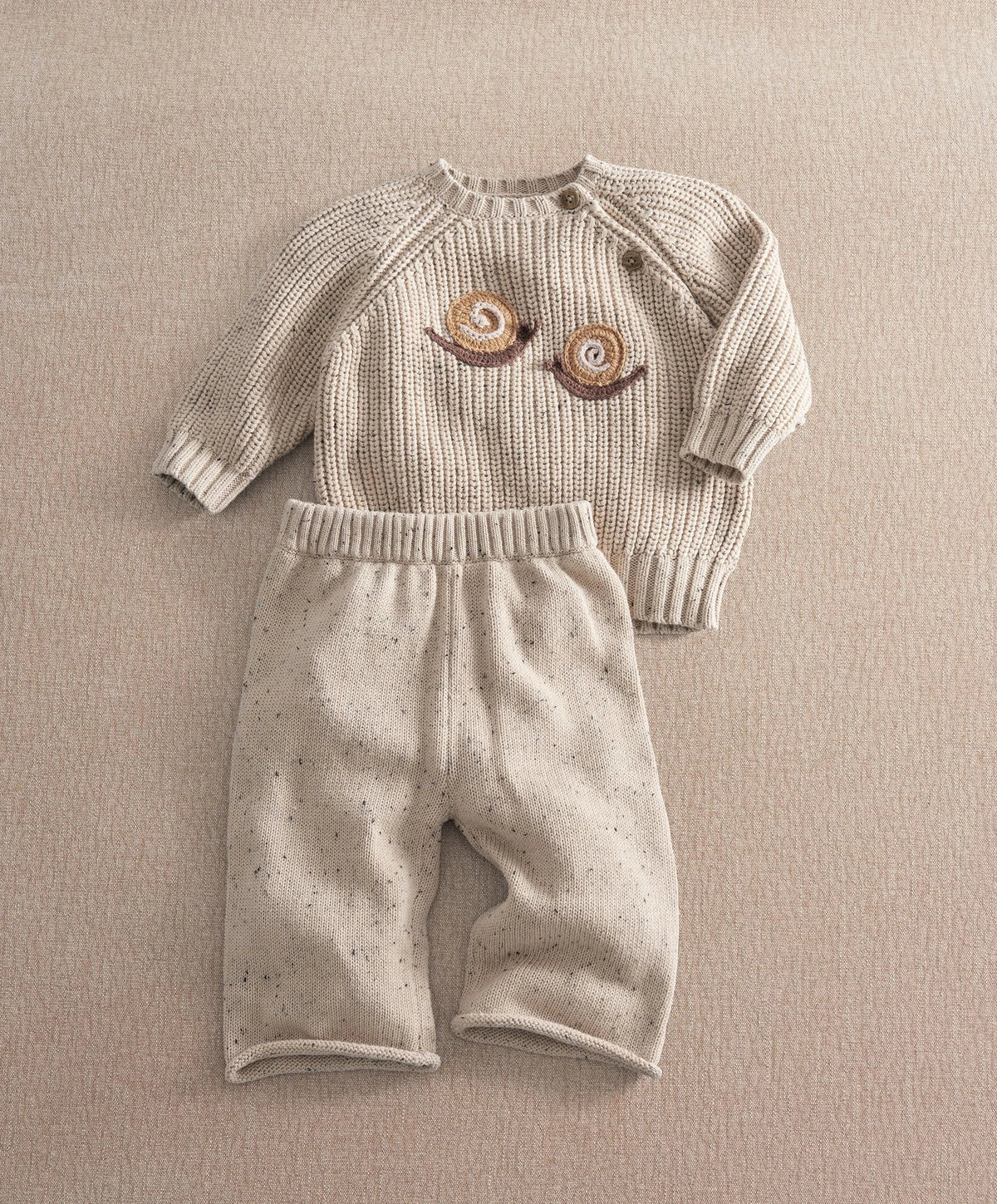 Cream knit sweater with brown snail appliques and matching speckled pants